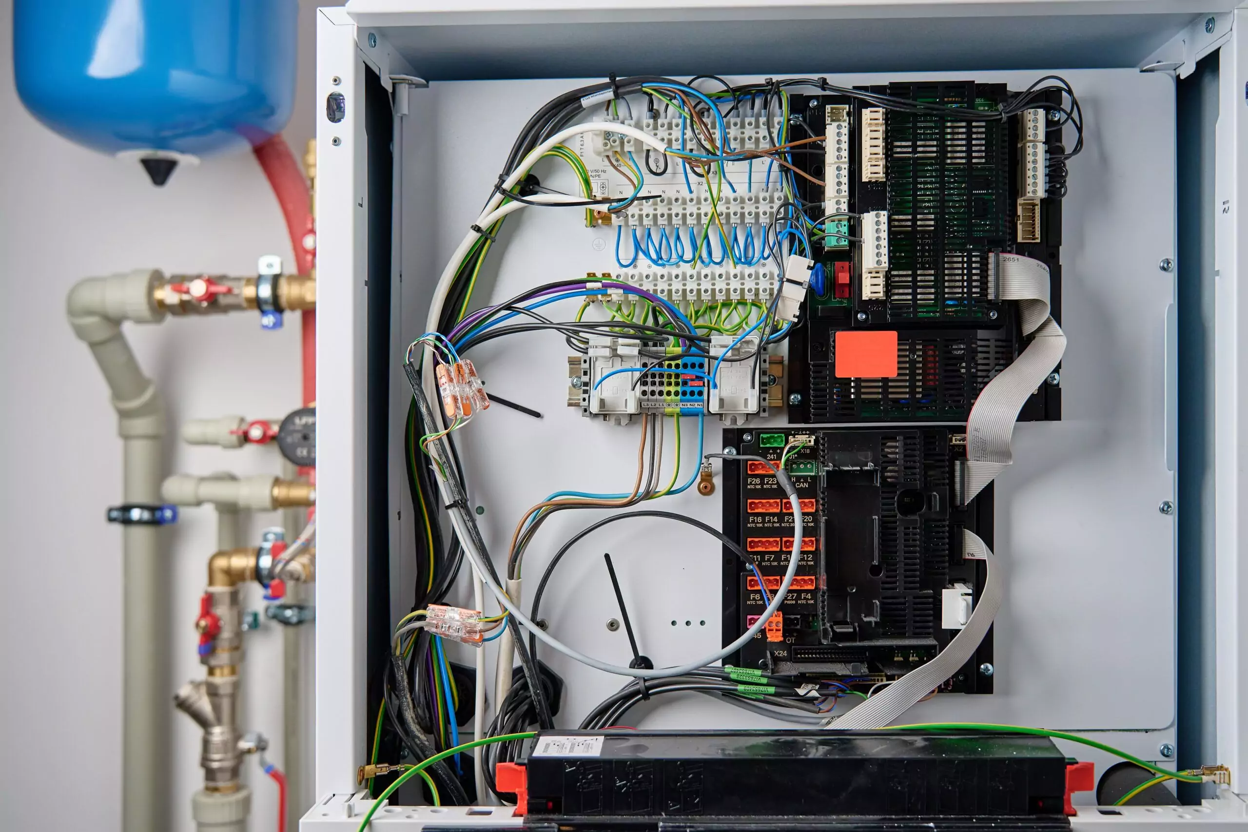 Interior of a boiler control panel showing complex electrical wiring and circuit boards.