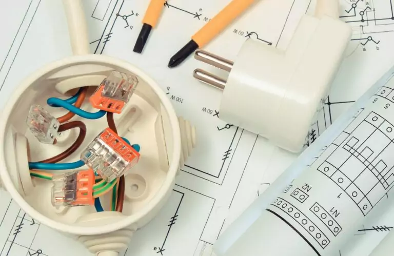 Electrical designer box with connections of electric copper wires and construction drawing of house. Components using in electrical installations. Accessories for engineering work