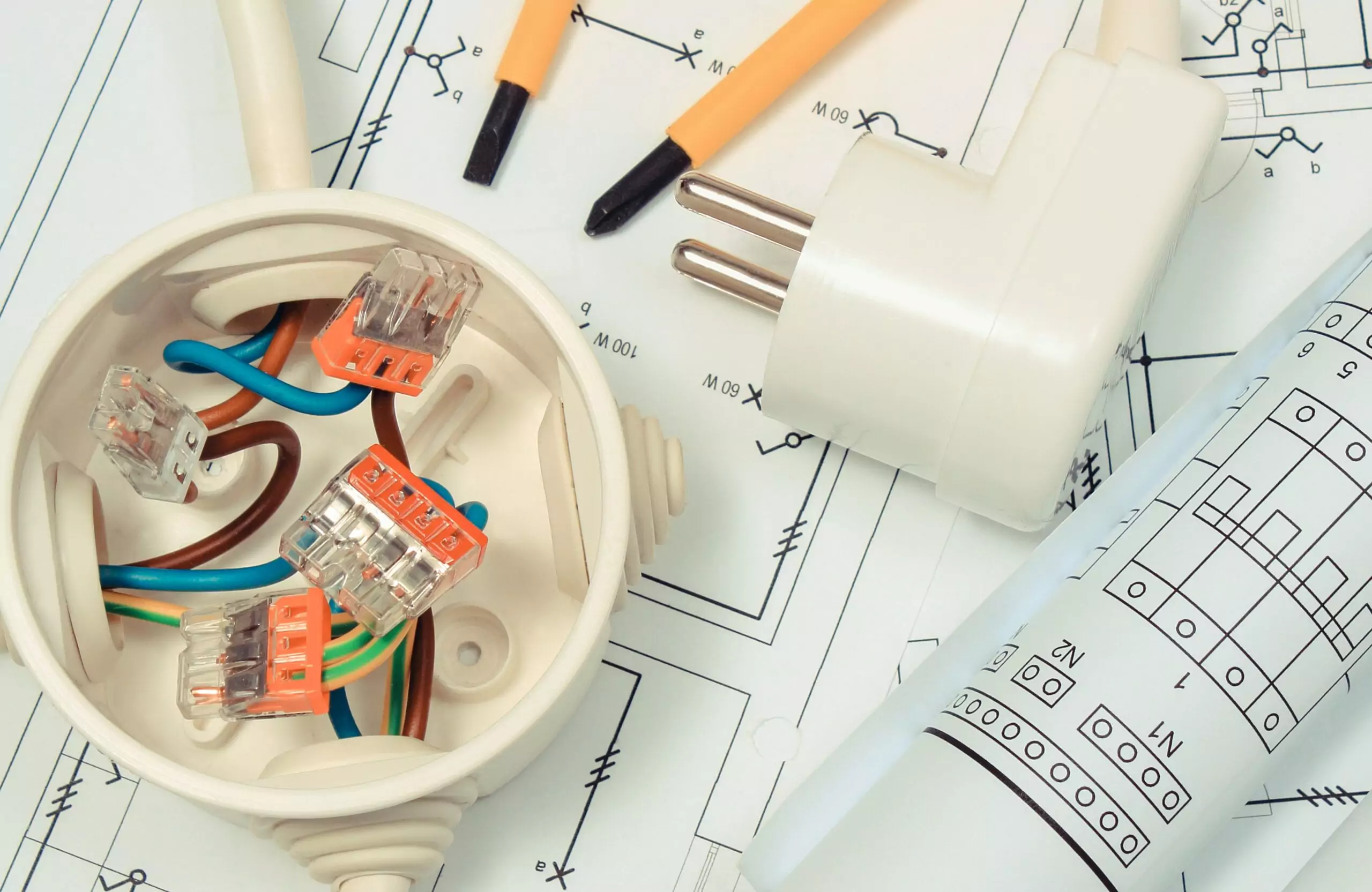 Electrical designer box with connections of electric copper wires and construction drawing of house. Components using in electrical installations. Accessories for engineering work