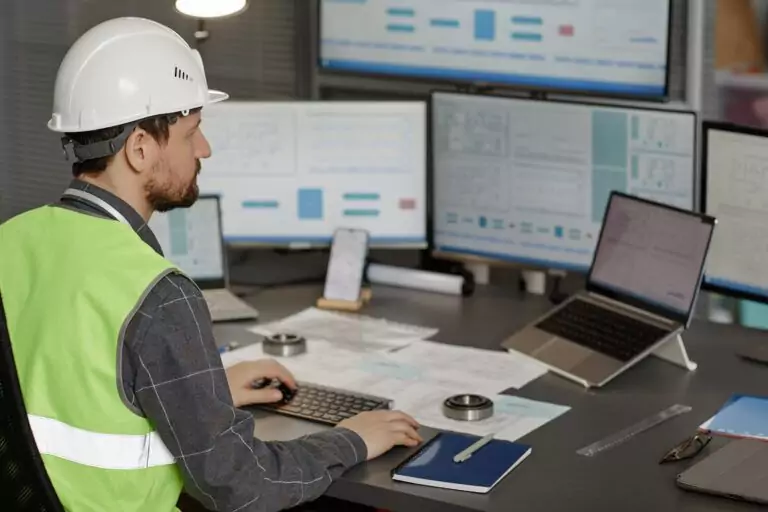 Engineer analyzing instrumentation software and control system diagrams on multiple monitors.