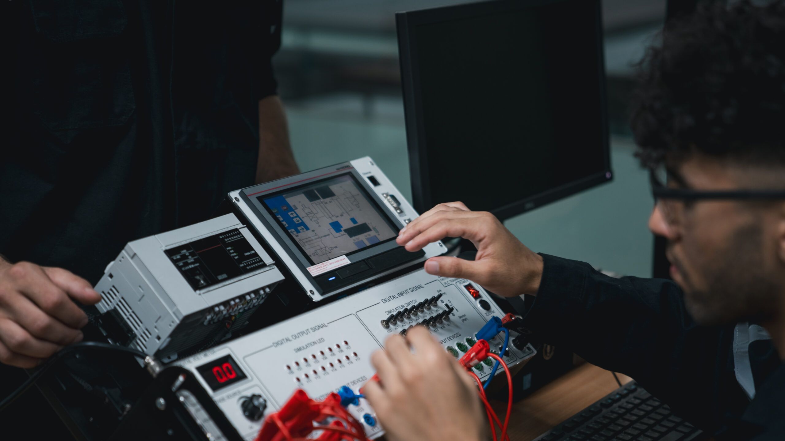 Student engineer Assembling Robotic Arm with computer in Technology Workshop. Service Engineer Holding Robot Controller and Checking Robotic Arm Welding Hardware.