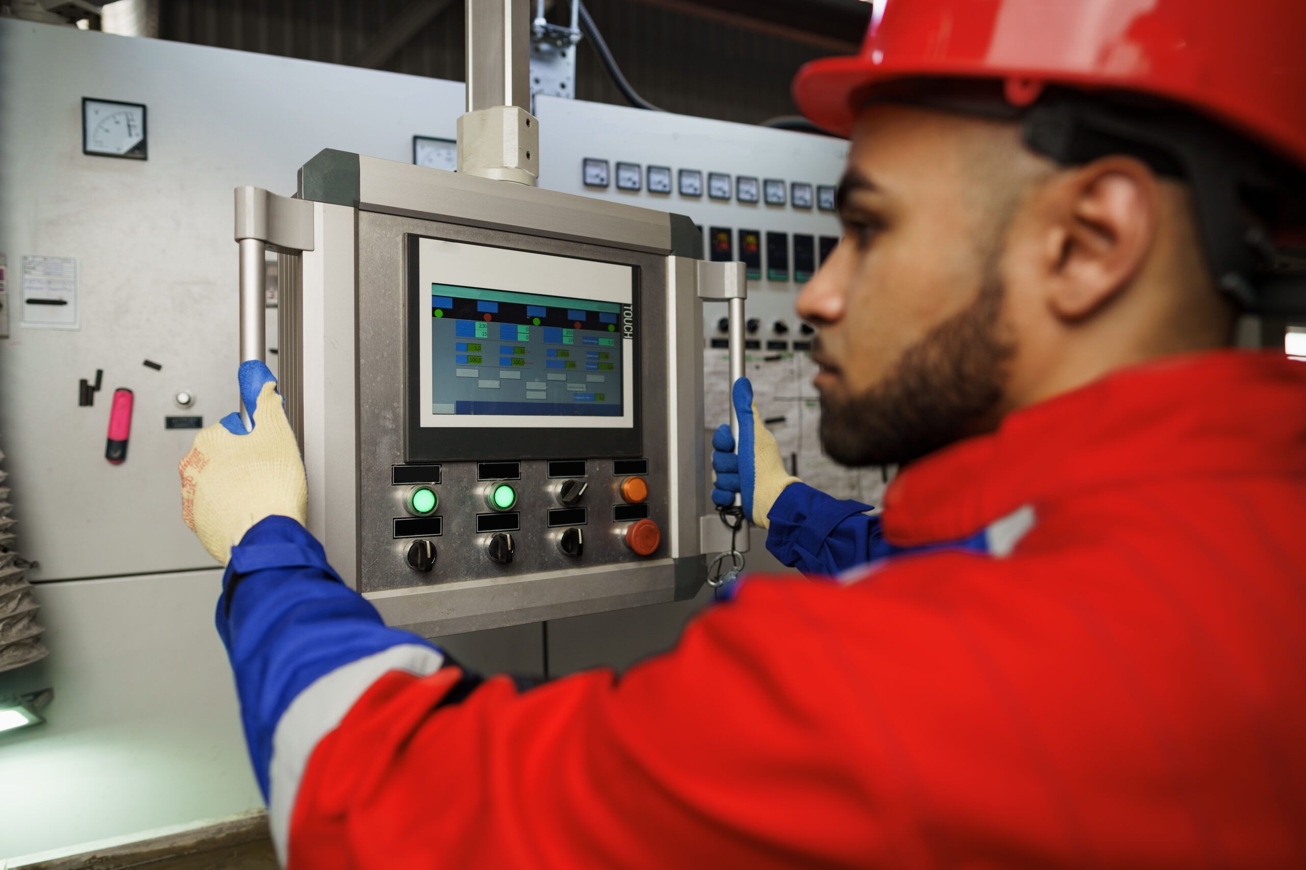 Engineer operating industrial control panel for monitoring and troubleshooting instrumentation and control systems.