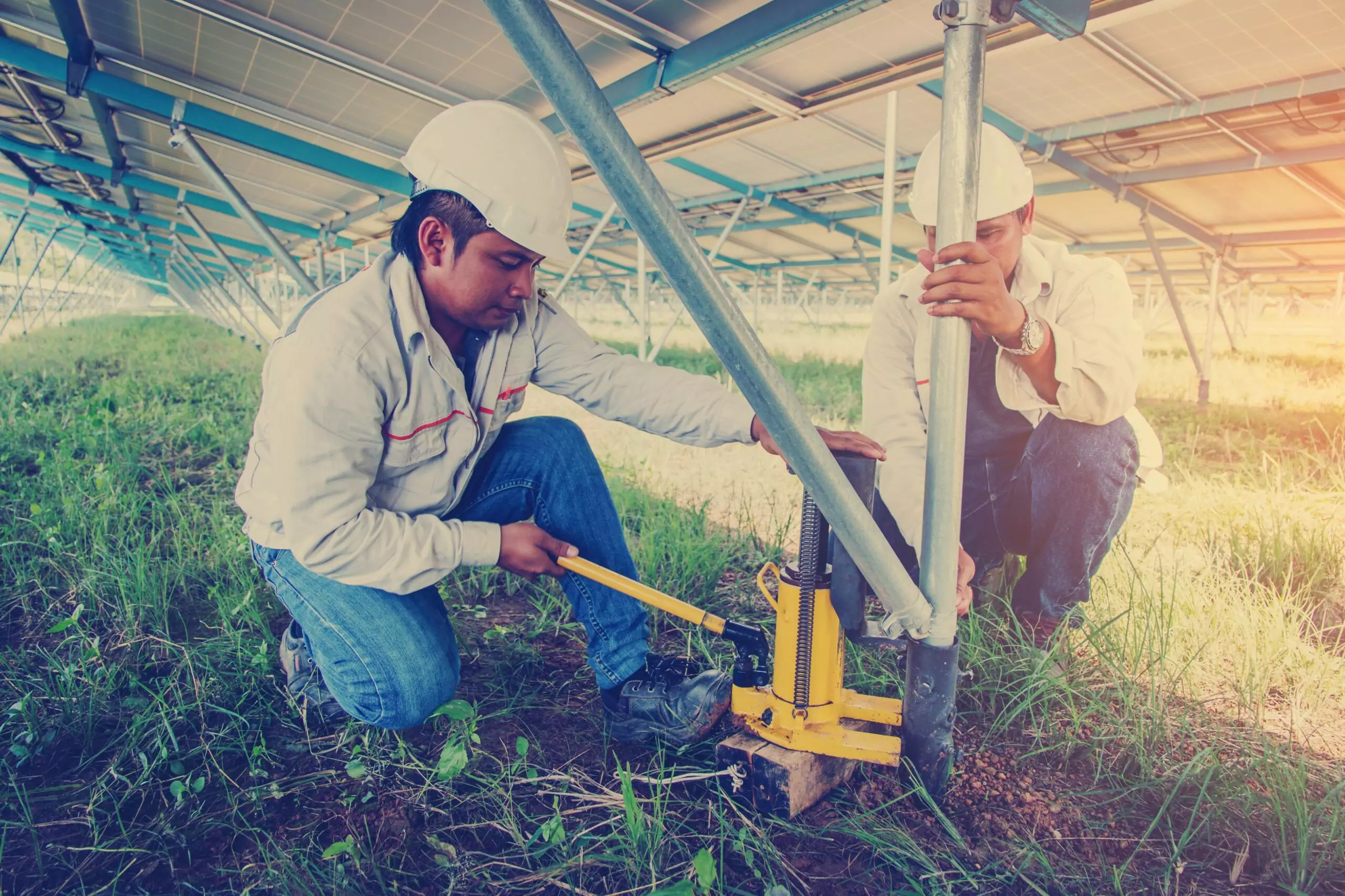 Engineers inspecting structural supports with hand tools during industrial control system troubleshooting and field maintenance