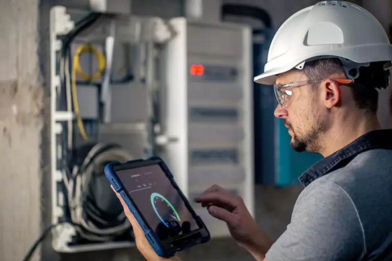 Technician using tablet to analyze industrial equipment vibration data for root cause analysis and condition monitoring