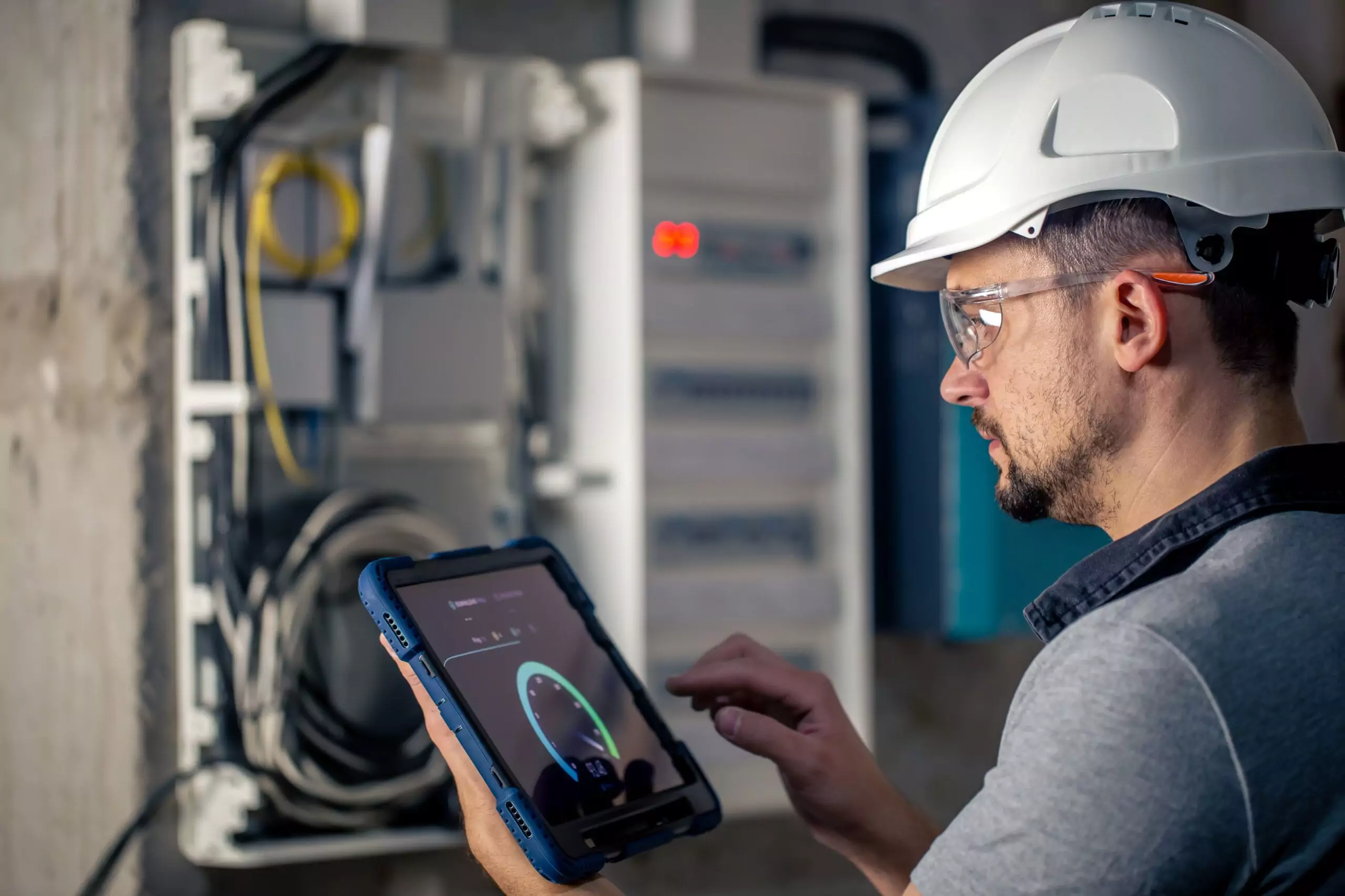 Technician using tablet to analyze industrial equipment vibration data for root cause analysis and condition monitoring