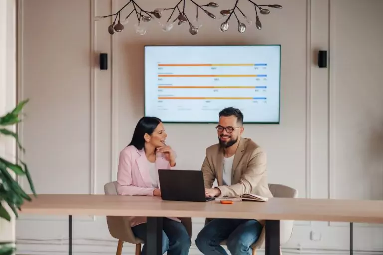 Maintenance and engineering professionals reviewing industrial maintenance management software data on a laptop