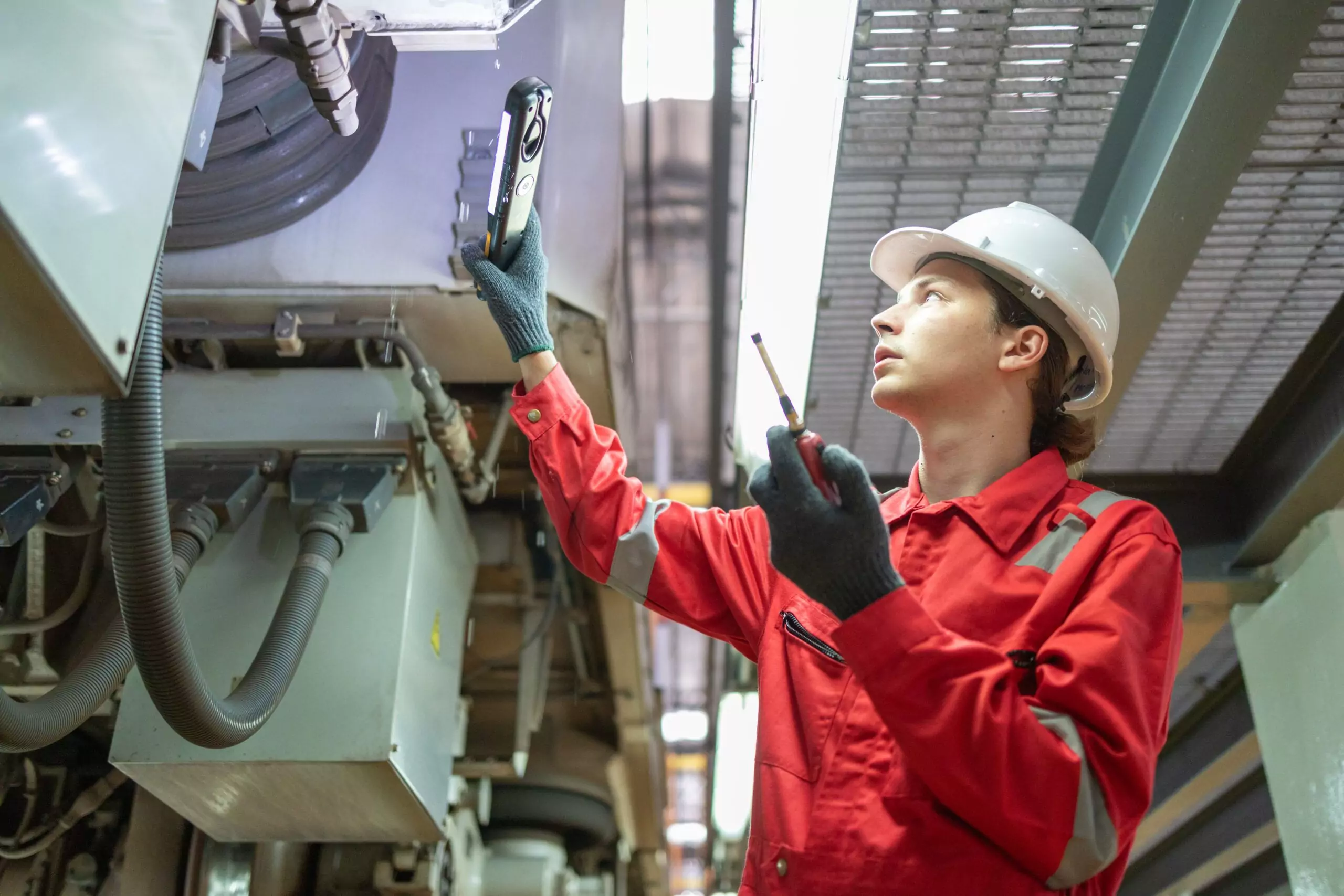 Technician performing predictive maintenance inspection with a handheld analyser on industrial equipment