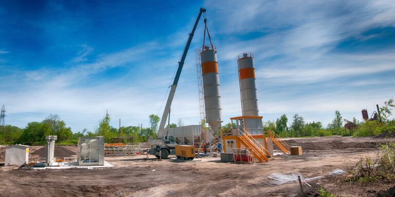 Concrete batching plant with silos and crane at an industrial construction site for deep foundation work