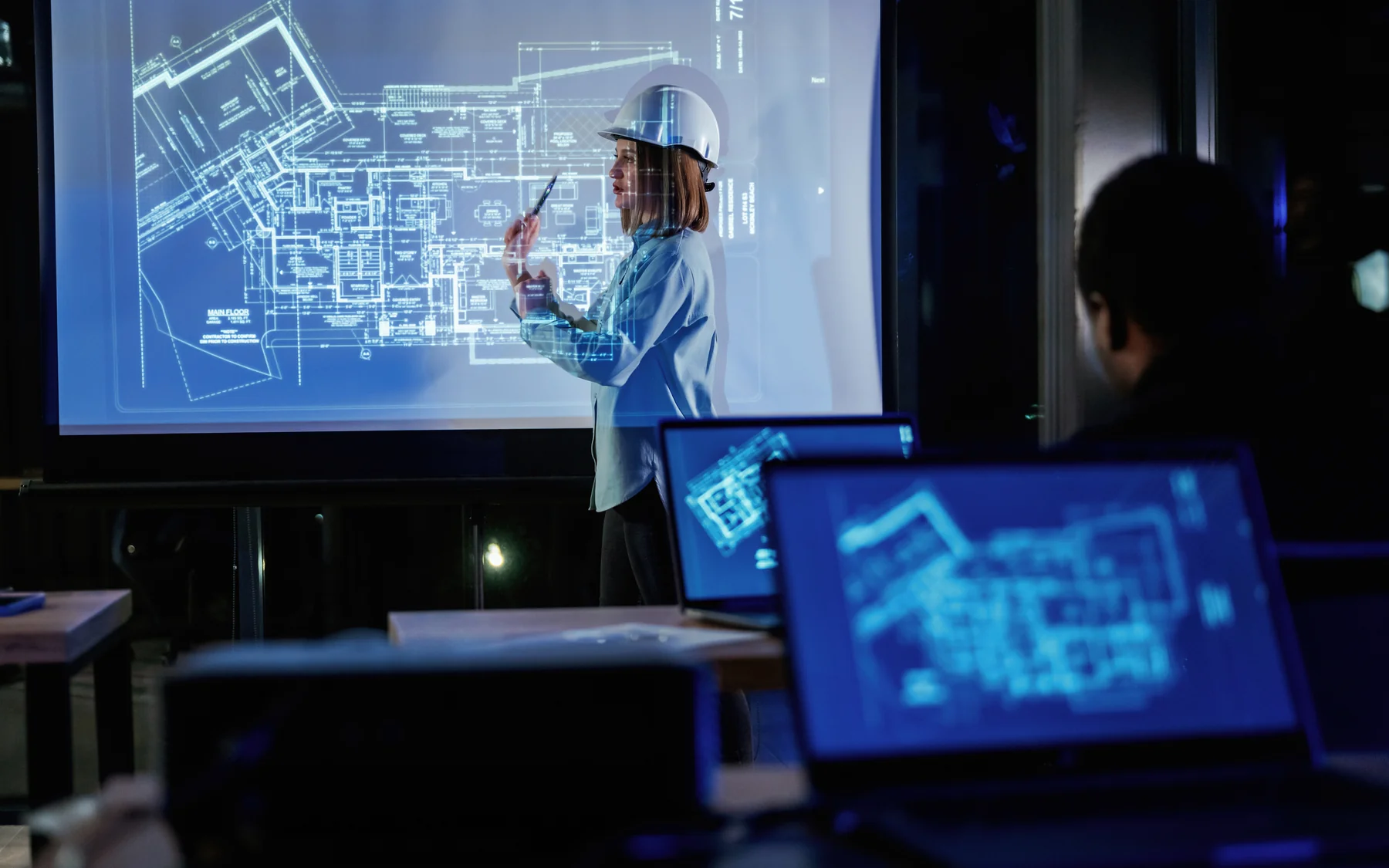 Engineer presenting architectural blueprints during office meeting